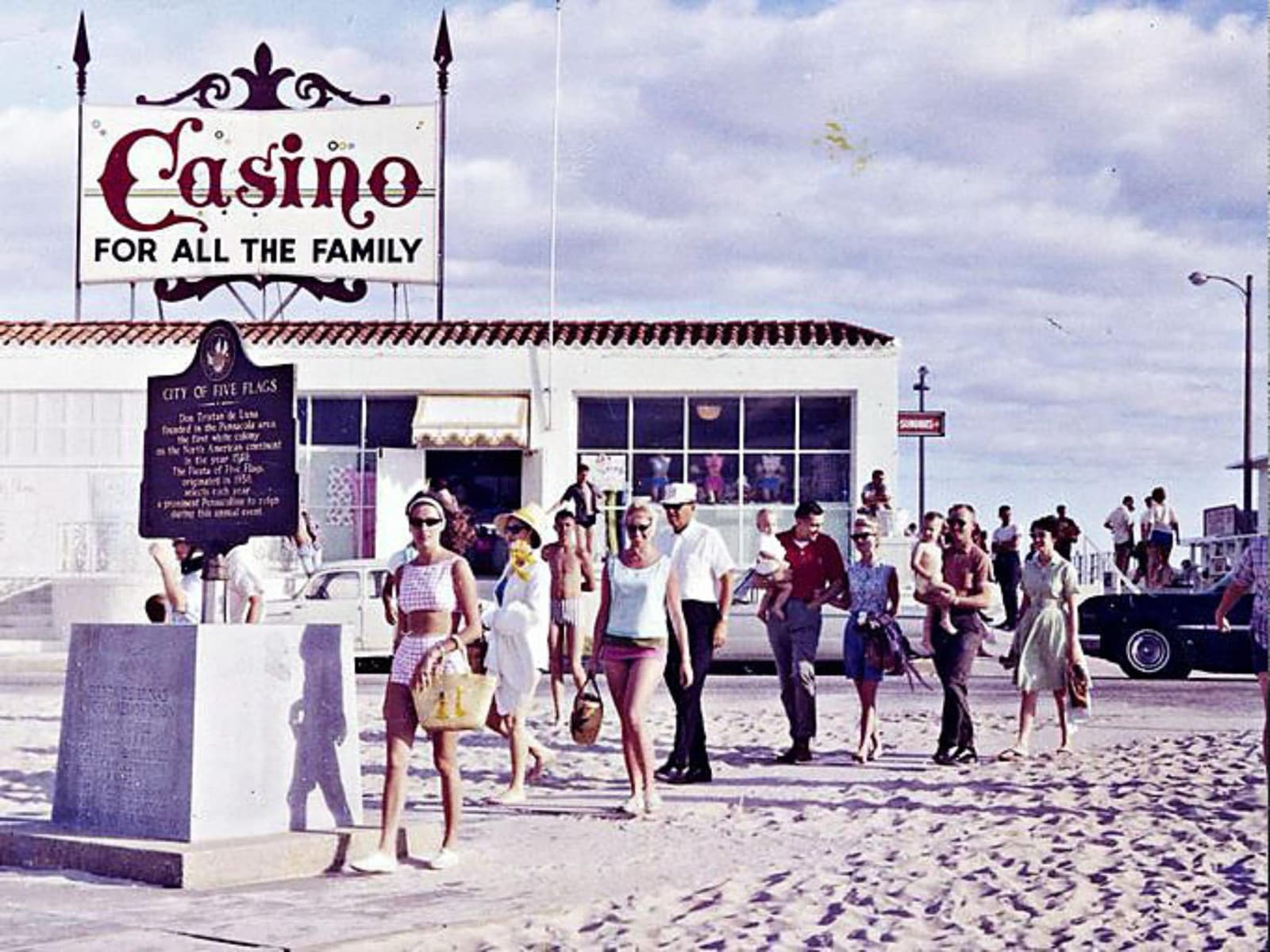 The historic Casino sign on Pensacola Beach reading 'Casino for all the family', with a 1960s crowd